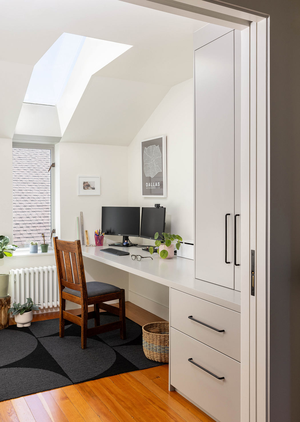 Bright home office with modern built-in cabinetry, wooden chair, and decorative accents.