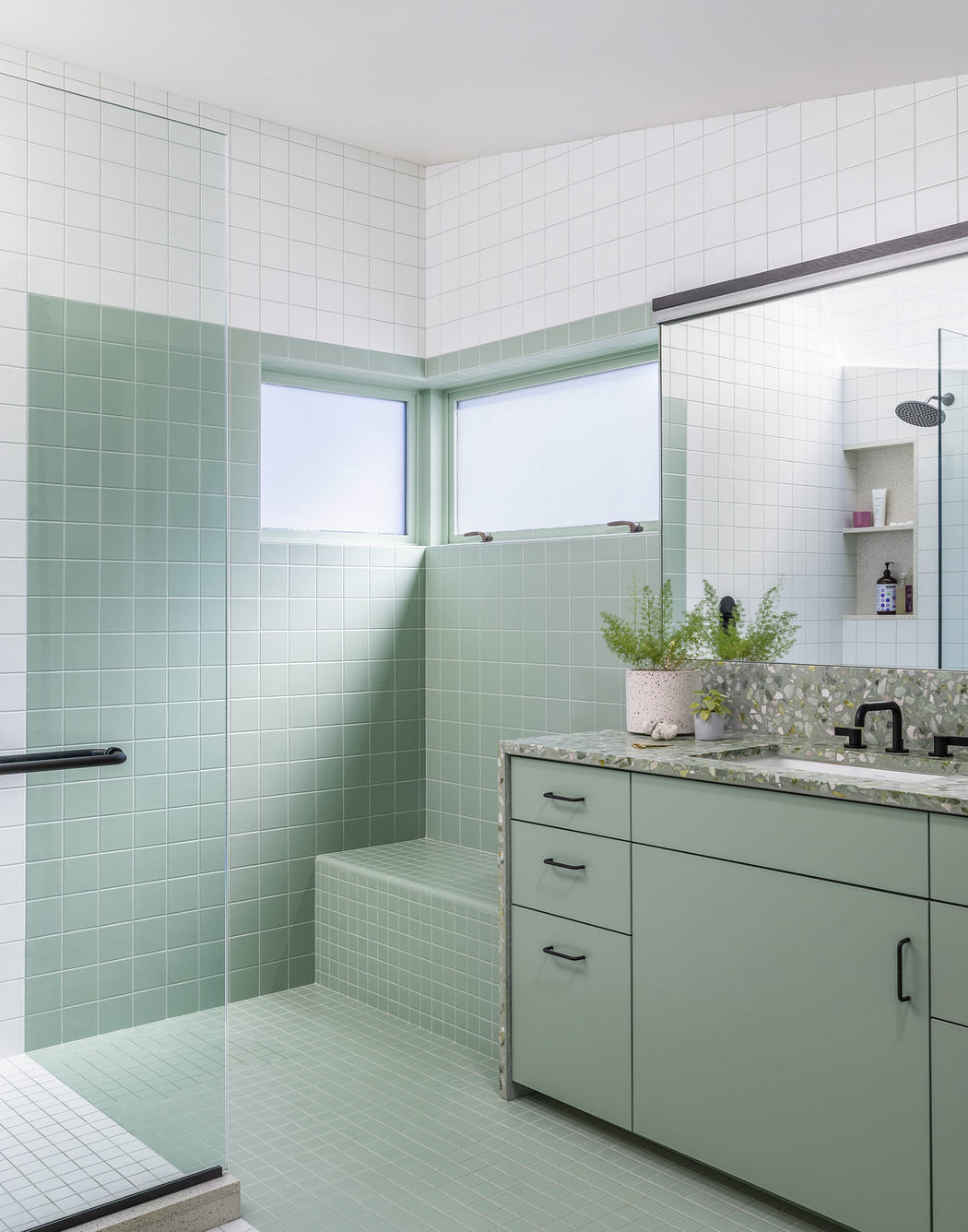 Minimalist bathroom with mint green tiles, modern vanity, and terrazzo countertop.