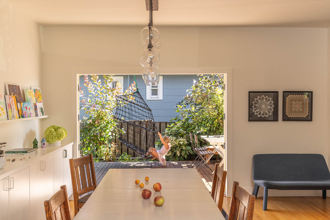 Cozy indoor space featuring wall art, pendant lighting, and a view of a lush outdoor deck.