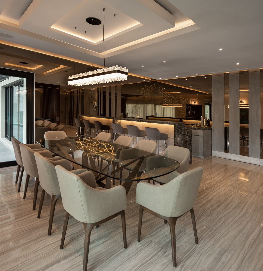 Sleek, modern dining room with a large glass table, plush chairs, and a stunning chandelier.