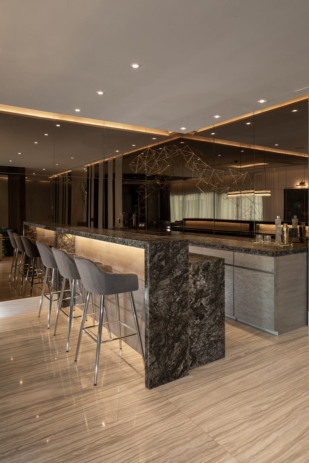 Sophisticated lounge with marble bar, geometric lighting, and modern furniture.