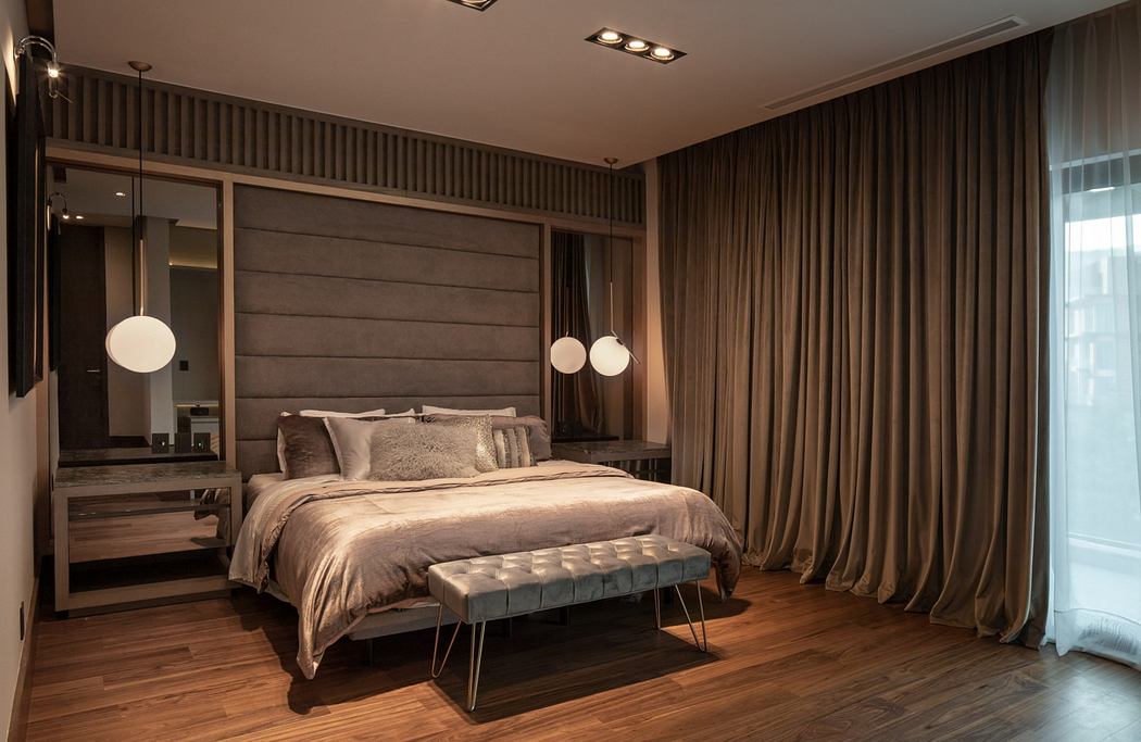 Elegant bedroom design with wooden paneled walls, plush bedding, and modern lighting.