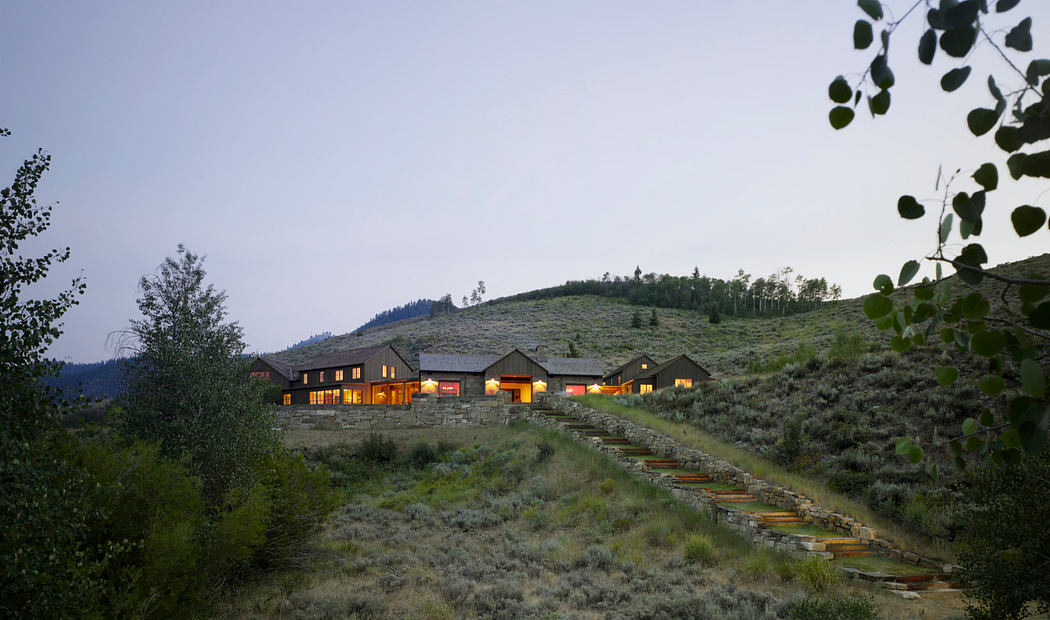 Rustic mountain resort with warm lighting and stone construction blending into hillside.
