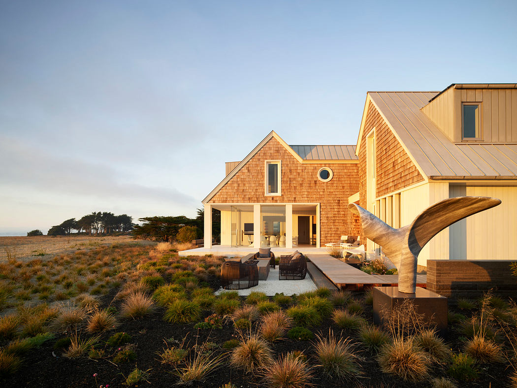 Coastal modern home with wood siding, gabled roof, and ample outdoor living space.