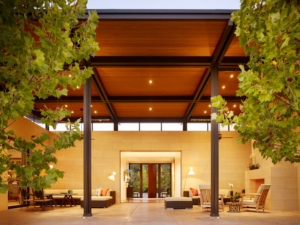 Warm-toned outdoor patio with wood-beamed ceiling, recessed lighting, and large windows.