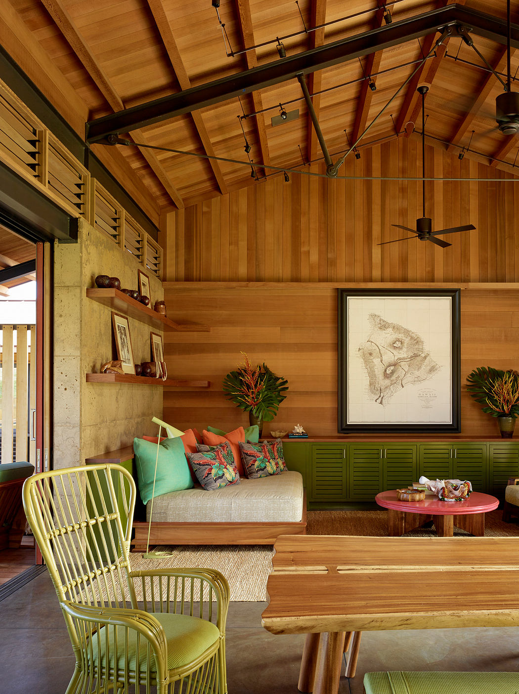 Warm, rustic interior with wooden beams, shelves, and furniture; tropical accents.