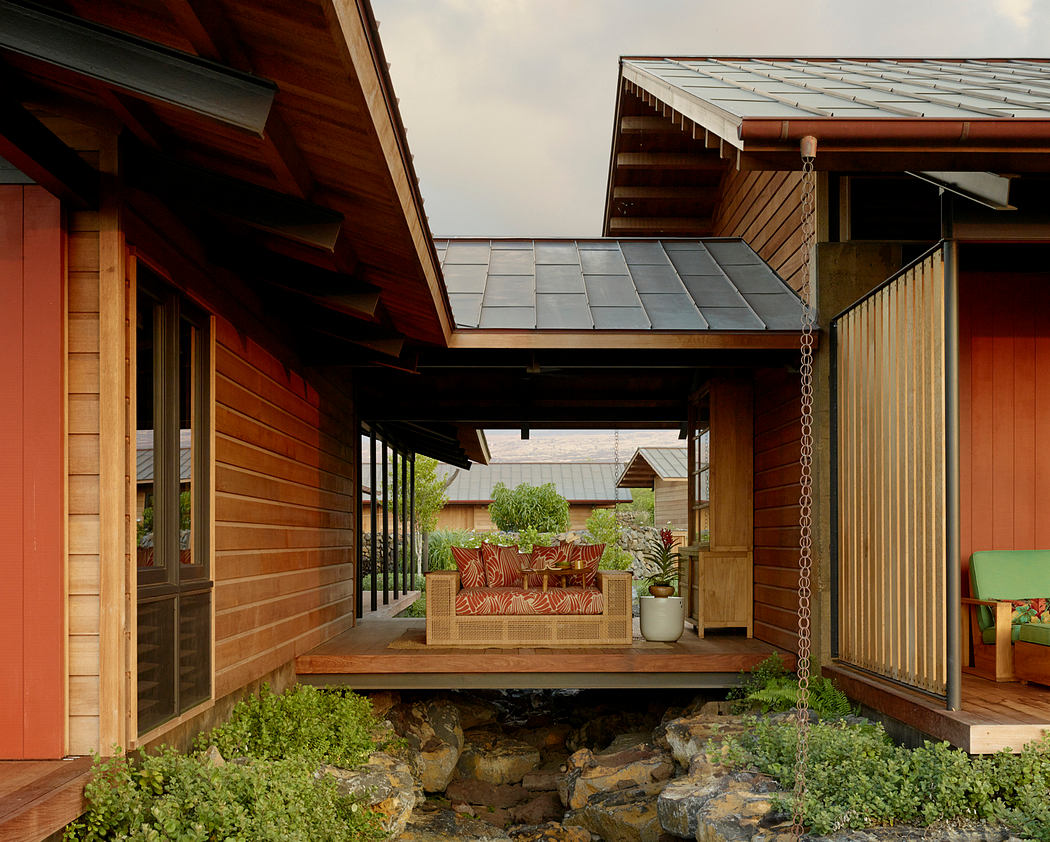 A rustic wooden lodge with a covered porch, slate roof, and lush vegetation.