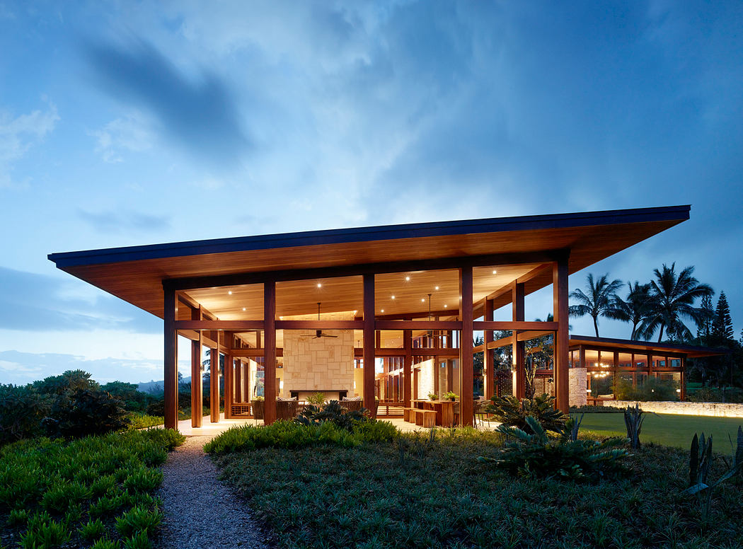 A modern tropical home with an expansive wood-framed structure and lush landscaping.