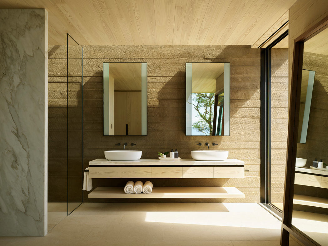 Luxurious contemporary bathroom with sleek wood vanity, vessel sinks, and large mirrors.