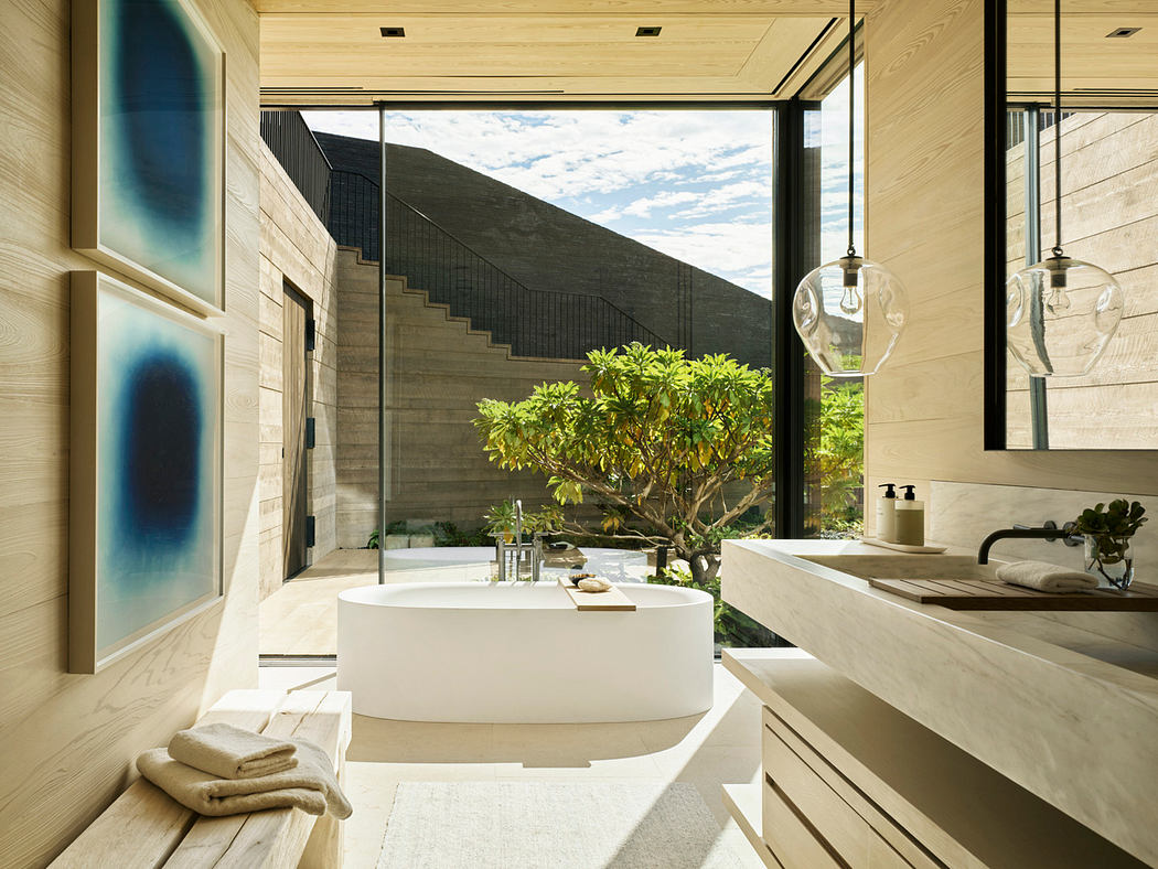 A luxurious bathroom with a contemporary design, featuring a freestanding bathtub, large windows, and a bonsai tree.