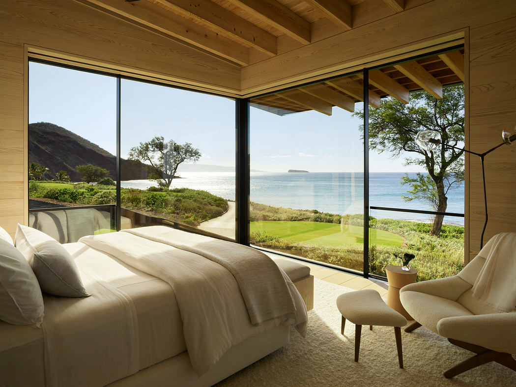 Spacious room with wooden ceiling, floor-to-ceiling windows, and scenic ocean view.