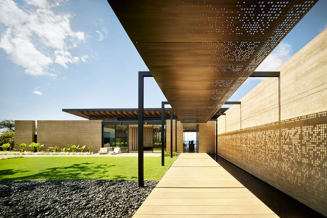 Striking modern architectural design featuring a perforated wood canopy, glass walls, and lush greenery.