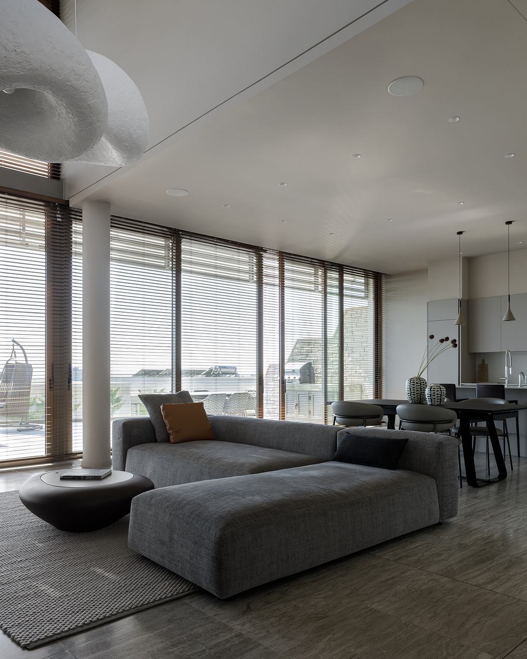 Sleek, modern living space with large windows, neutral color palette, and minimalist furniture.