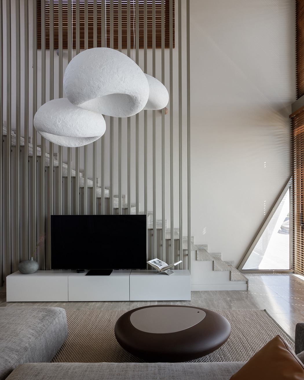 Minimalist living room with sculptural lighting fixtures, modern furniture, and natural accents.