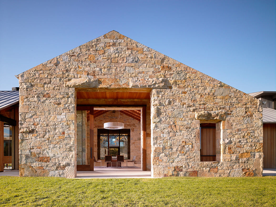 Impressive stone facade with wooden beams and arched entryway leading into inviting interior.
