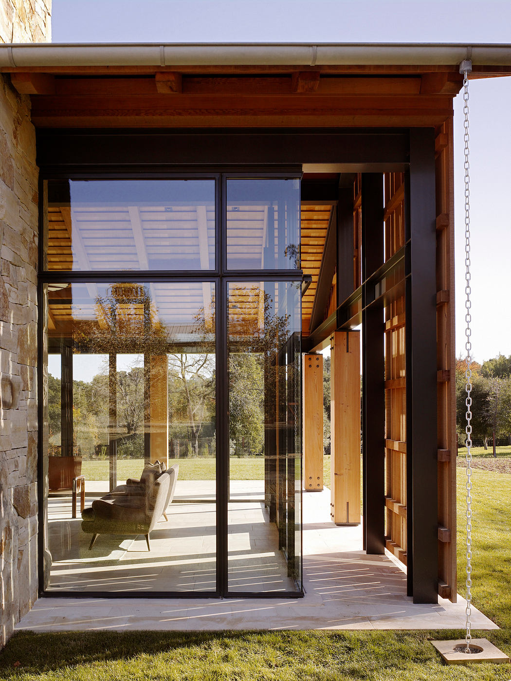 Rustic wooden structure with glass walls, showcasing the outdoor scenery.