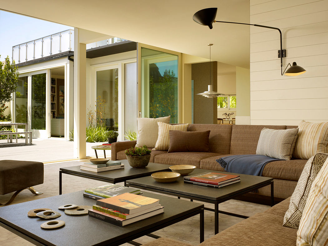 A spacious living room with large windows, modern furniture, and a cozy seating area.