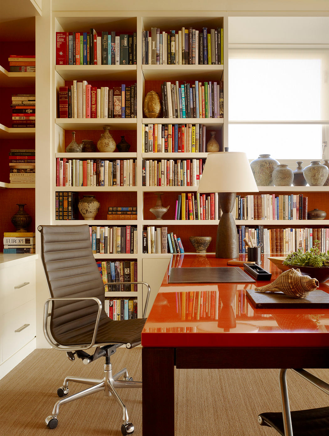 Cozy home office with built-in bookshelves, desk, and decorative elements.