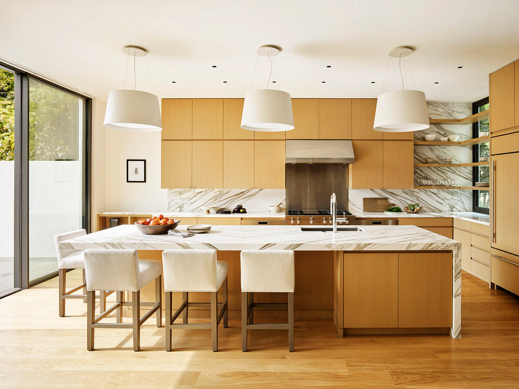 Spacious modern kitchen with marble countertops, wooden cabinetry, and pendant lights.