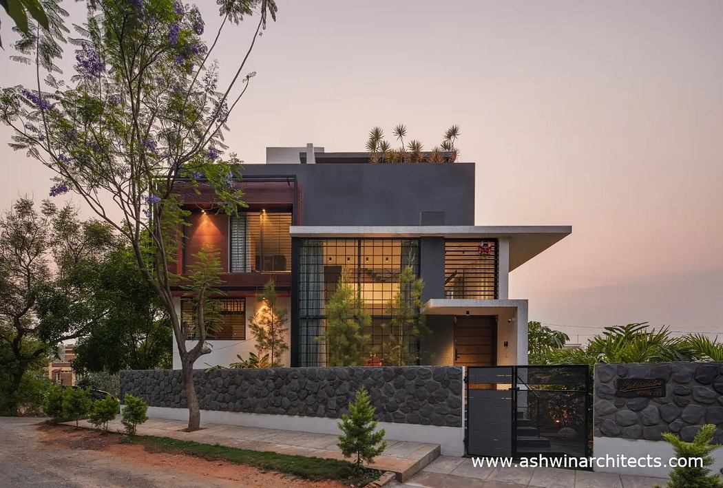Contemporary home features stone walls, tiered roofline, and thoughtful landscaping.