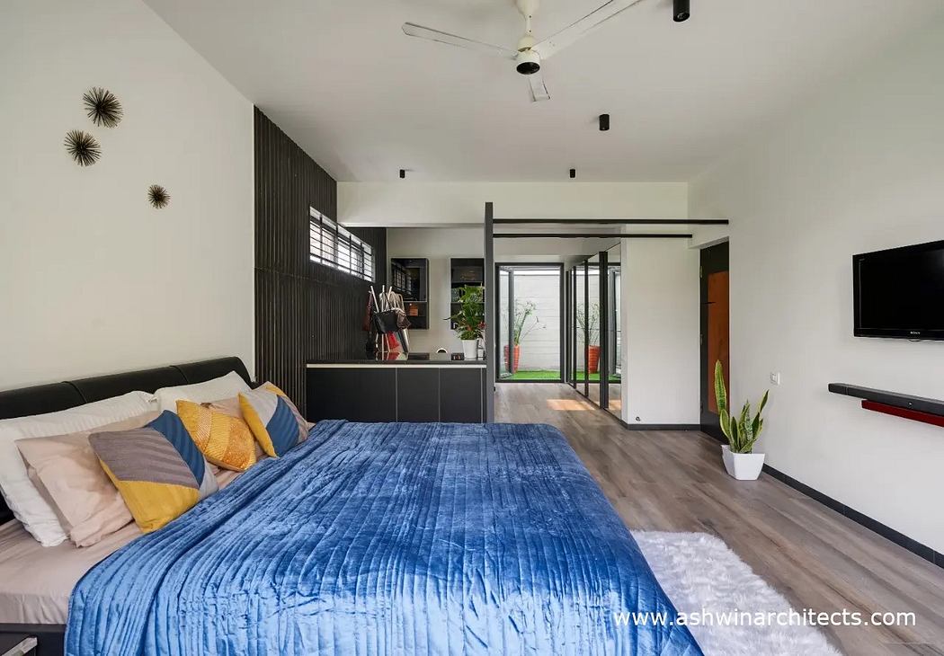Minimalist bedroom with dark accents, built-in storage, and access to an outdoor space.