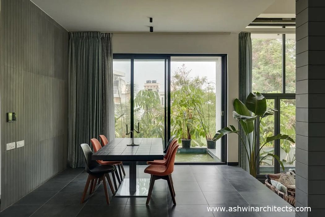 A modern dining area with a large window offering views of the lush, verdant landscape outside.