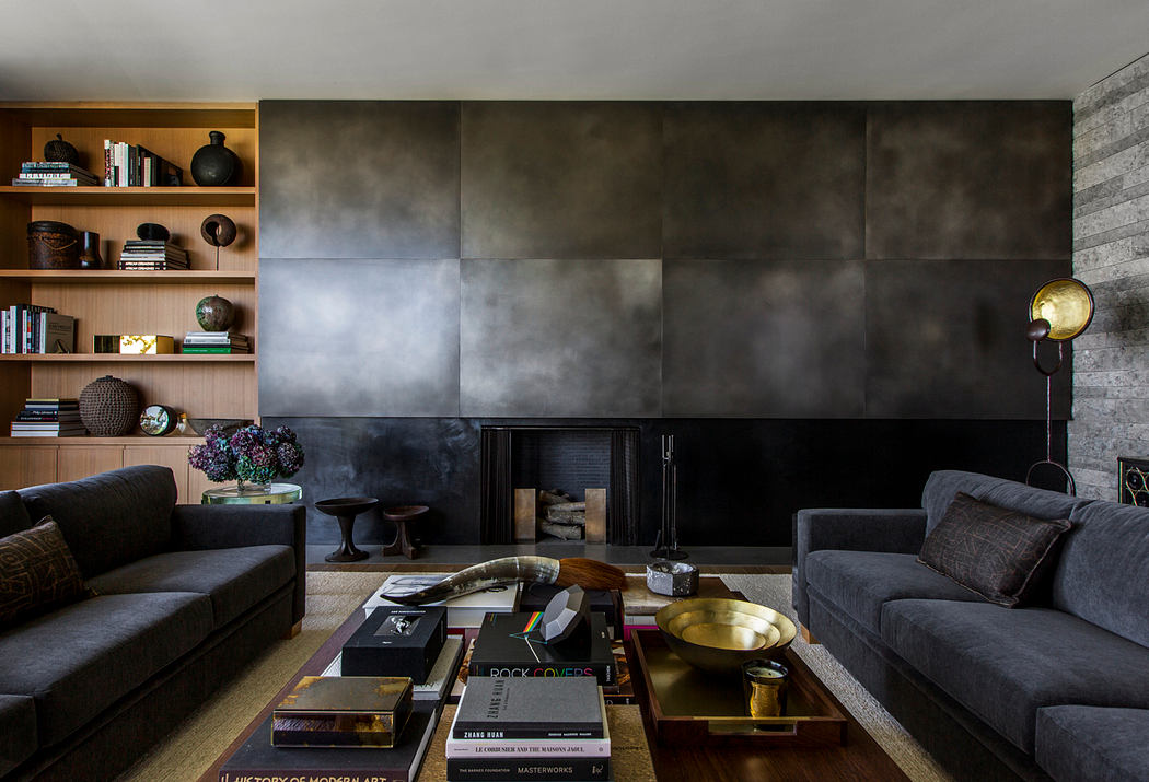 A moody, industrial-inspired living room with concrete walls, floating shelves, and a warm-hued fireplace.