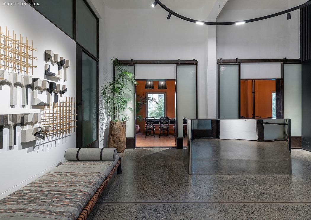 Minimalist reception area with patterned walls, earthy tones, and sliding glass doors.