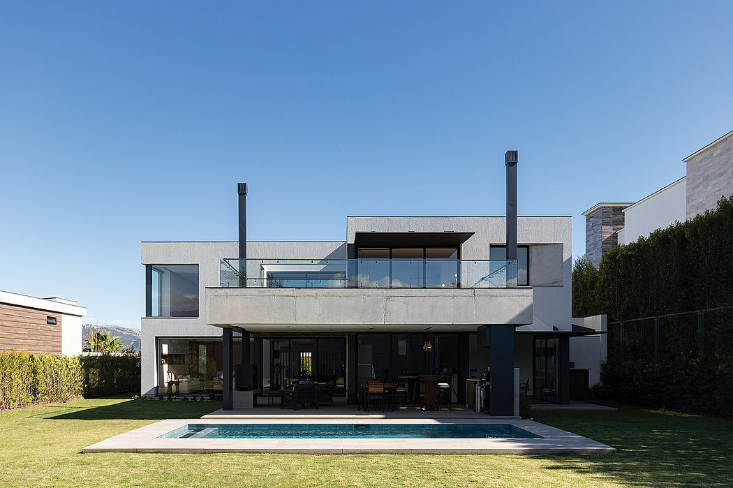 Modern, concrete, and glass house with a swimming pool and lush greenery around.