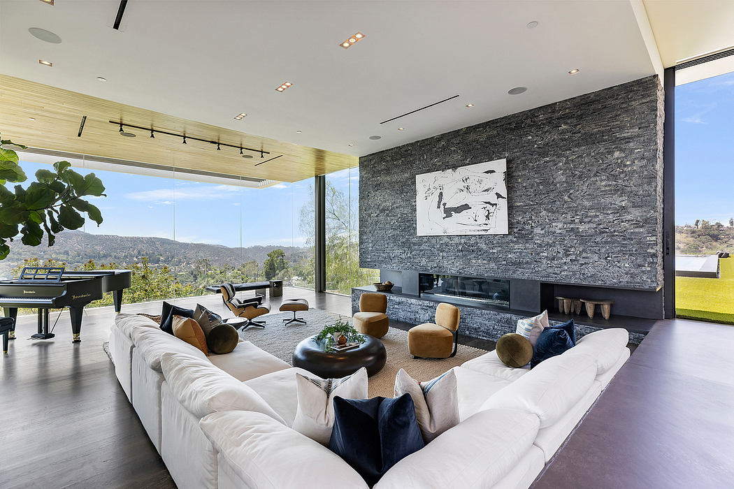 Spacious modern living room with stone accent wall, large windows, and plush seating.
