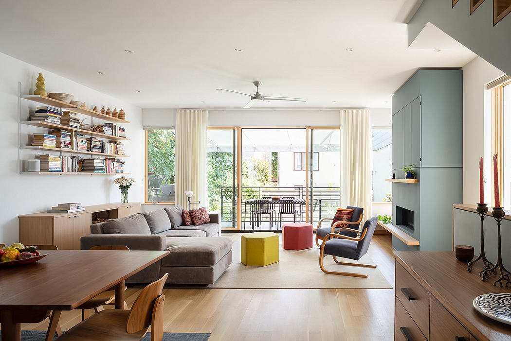 Open-concept living area with built-in shelves, wooden furniture, and a sliding glass door leading to a balcony.