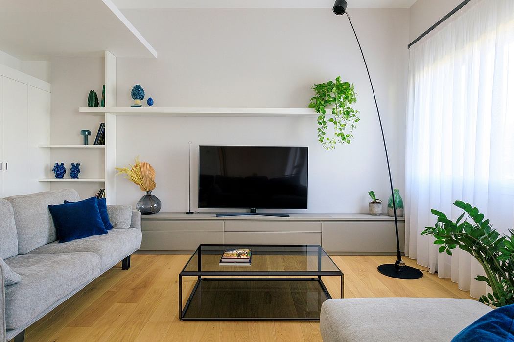 Minimalist living room with white walls, modern furniture, and hanging plant accents.