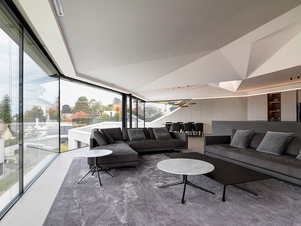 Spacious, modern living room with floor-to-ceiling windows, sleek furnishings, and minimalist design.
