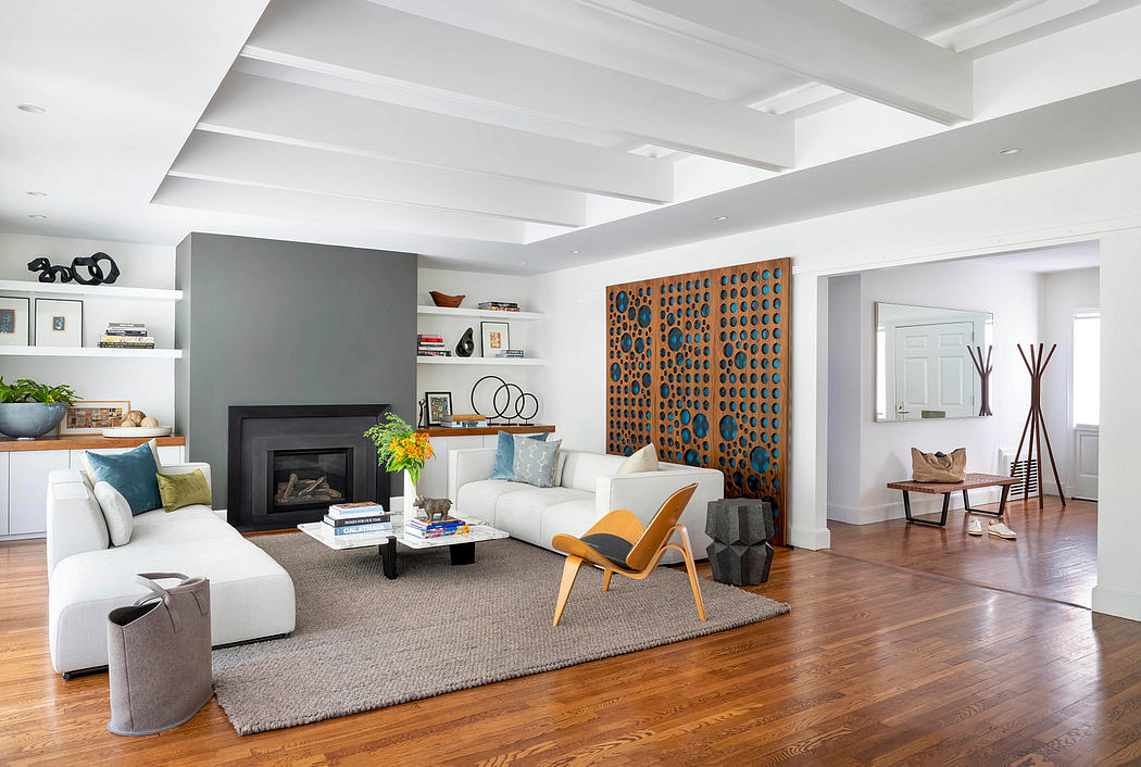 Bright, modern living room with wood floors, fireplace, built-in shelves, and colorful artwork.