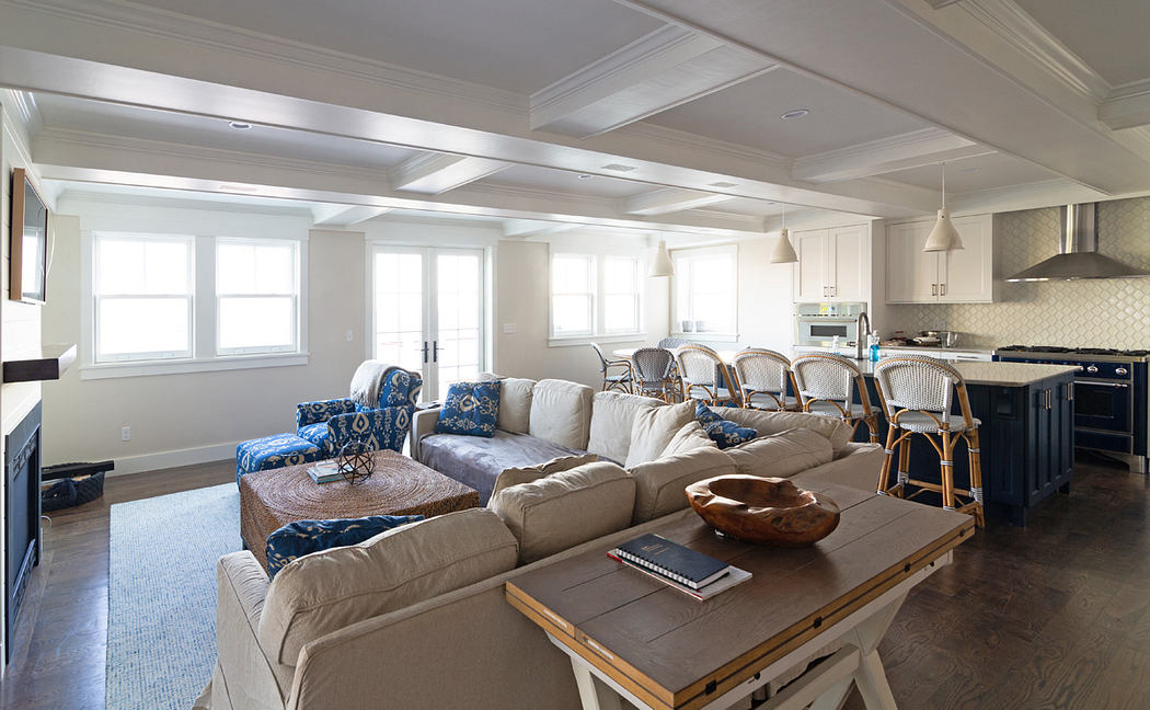 Spacious open-concept living area with high ceilings, large windows, and neutral decor.