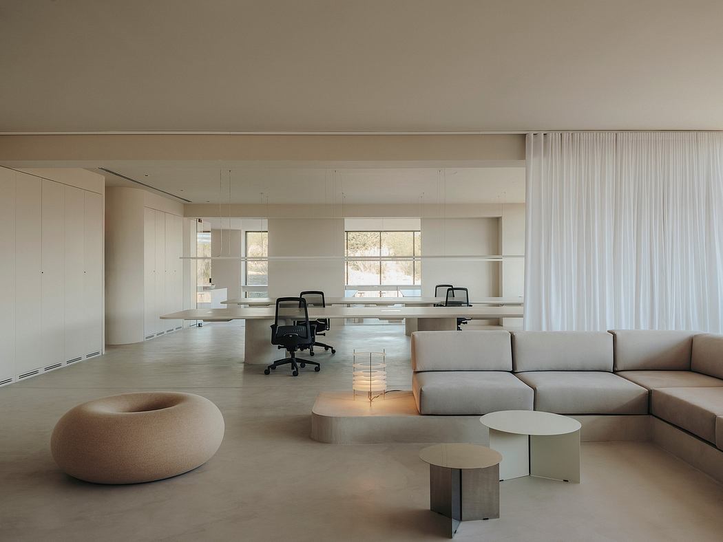 A minimalist, open-plan office space with a neutral color palette and modern furnishings.