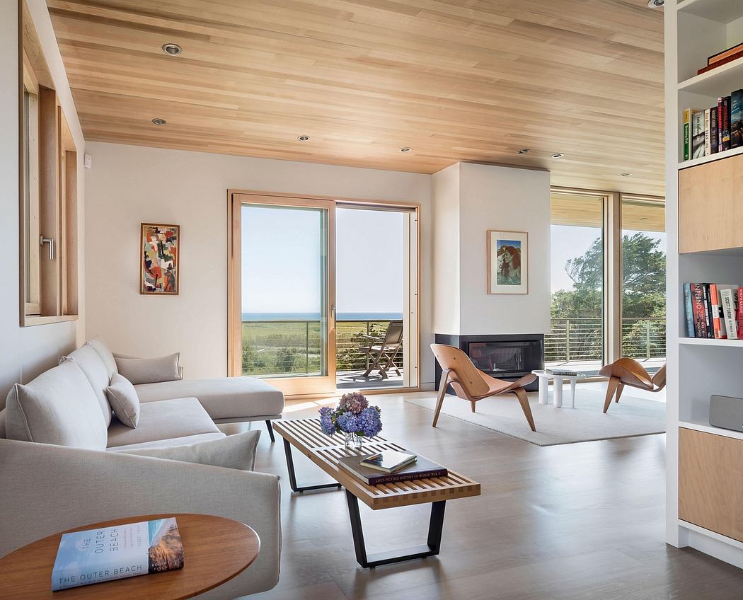 Bright, airy living room with wood-paneled ceiling, large windows, and modern furniture.