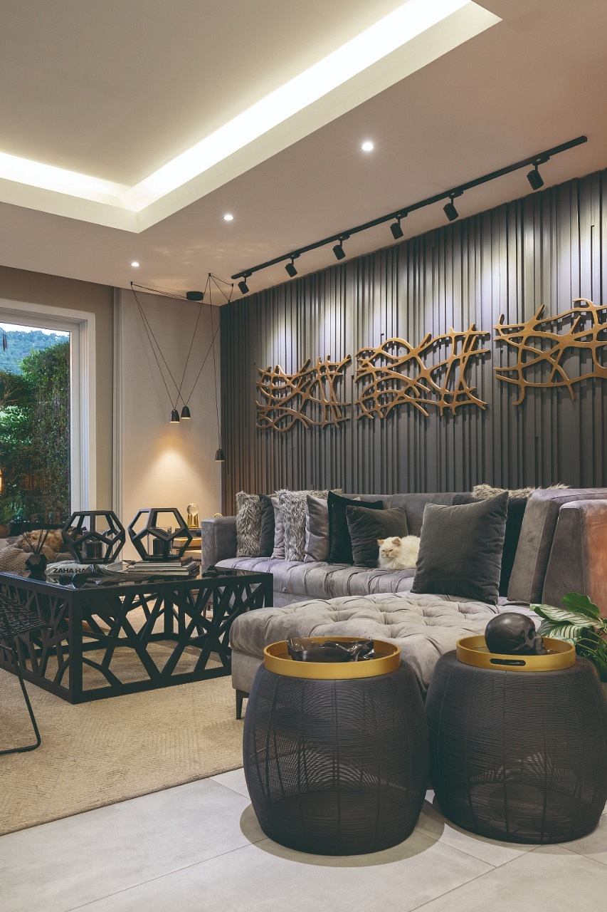 Sleek, modern living room with intricate wooden wall art and plush, tufted seating.