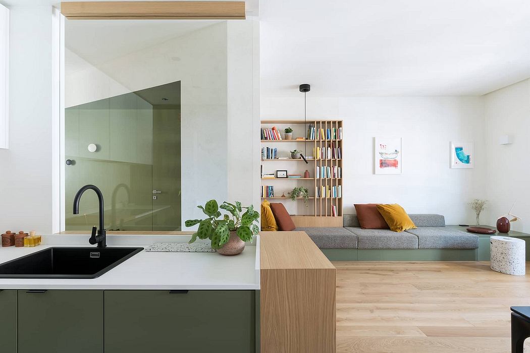 An open-concept living space with a sleek kitchen, wooden shelving, and a cozy sofa area.