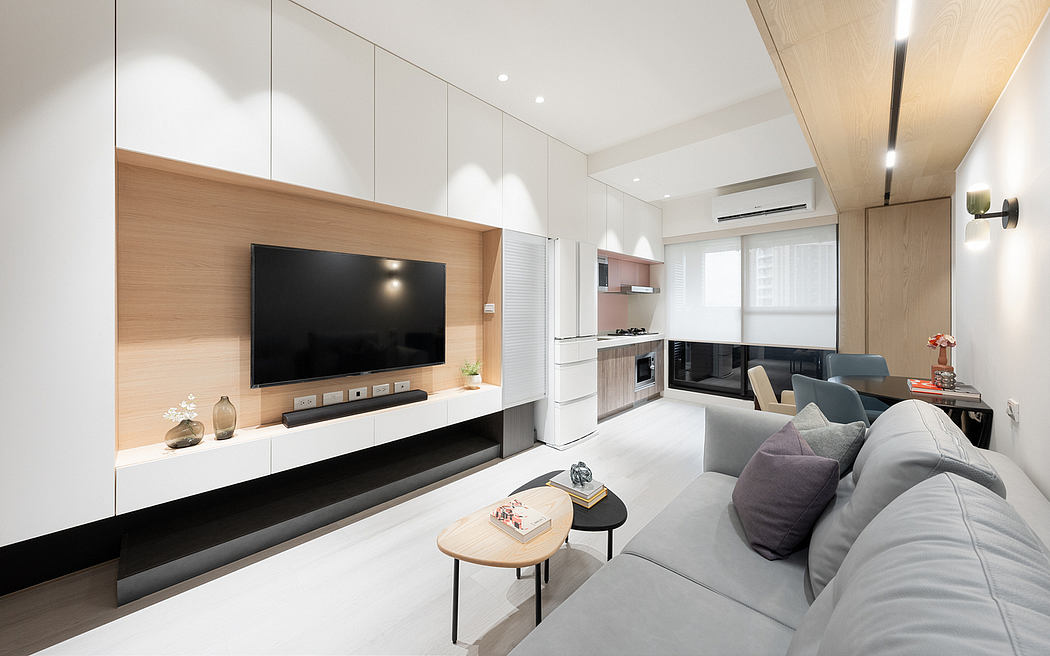 Sleek, minimalist living room with a large TV console, neutral color palette, and modern furniture.
