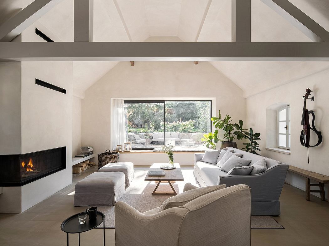 Cozy living room with vaulted ceiling, large windows, and a modern fireplace.