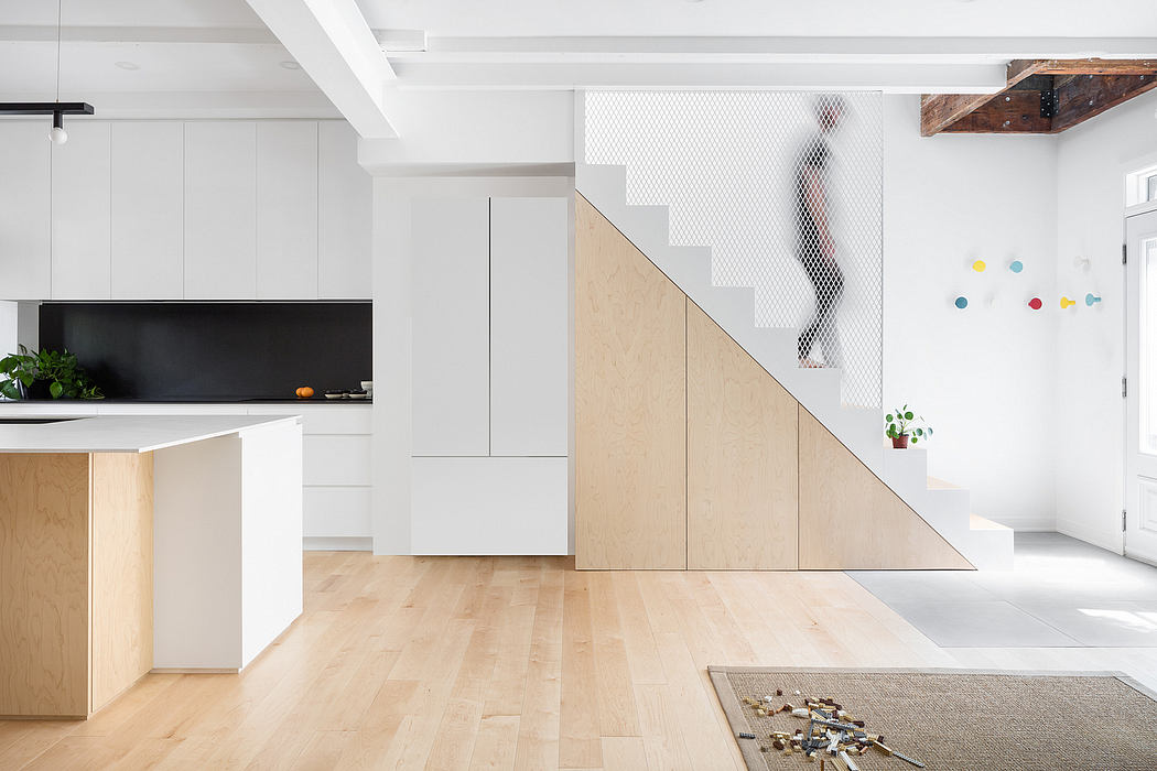 Sleek, minimalist kitchen with unique staircase and exposed beams in modern interior.