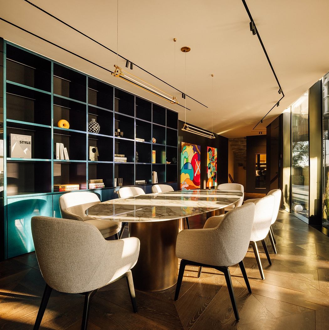 Modern dining room with circular glass-topped table, built-in shelves, and colorful artwork.
