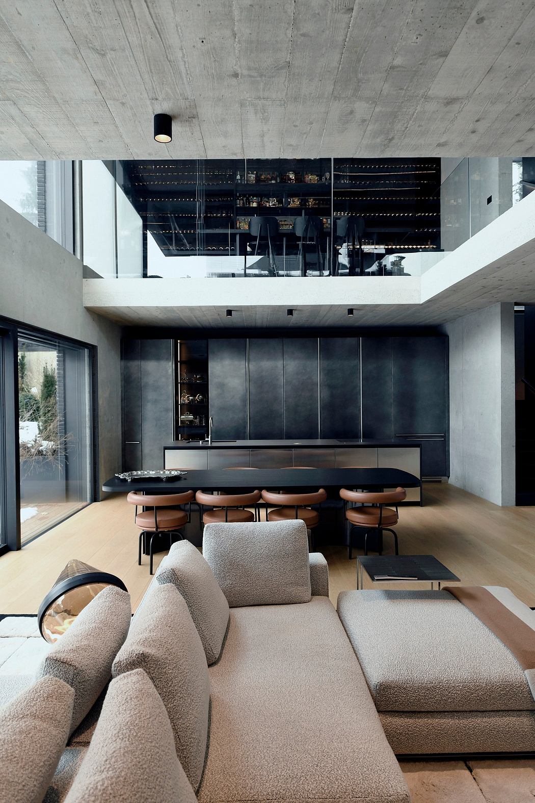 Minimalist, open-concept living space with concrete ceiling, modular furniture, and a wet bar.