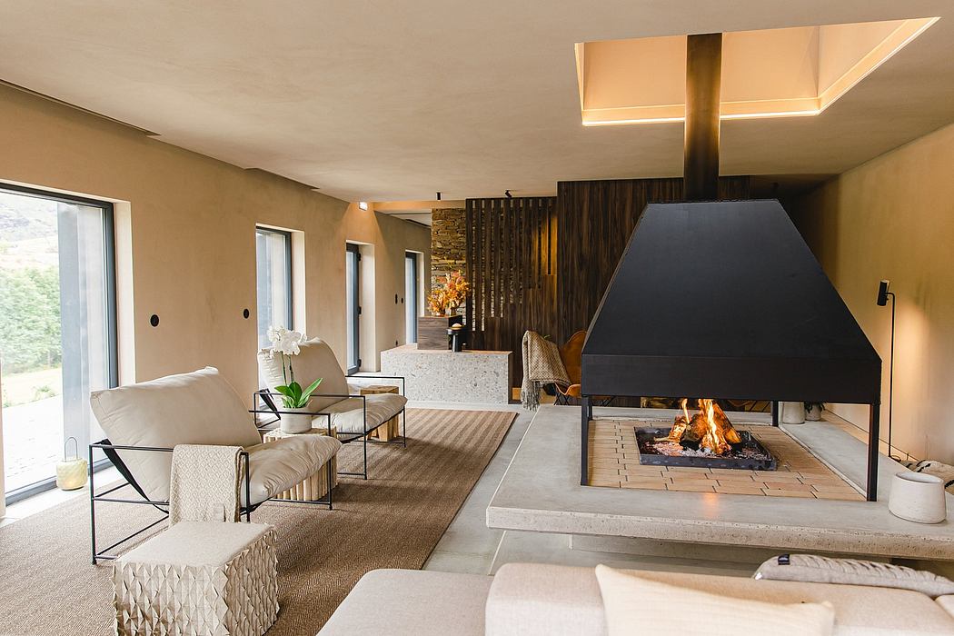 Modern, minimalist living room with large fireplace, glass doors, and natural decor.