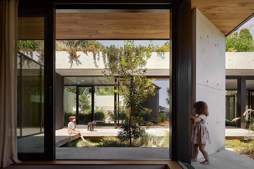 Modern minimalist home with large glass windows, wooden accents, and outdoor greenery.