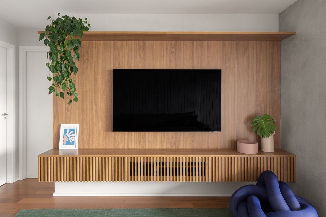 Minimalist living room with wooden TV stand, indoor plants, and modern artwork.