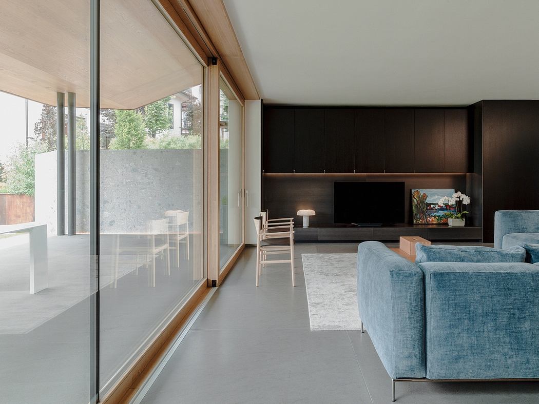 Modern open-concept living room with floor-to-ceiling glass doors, sleek cabinetry, and plush seating.