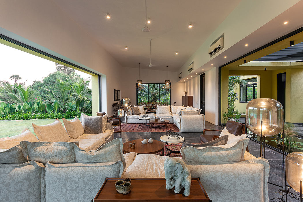 Spacious, open-concept living area with floor-to-ceiling windows, plush seating, and tropical decor.