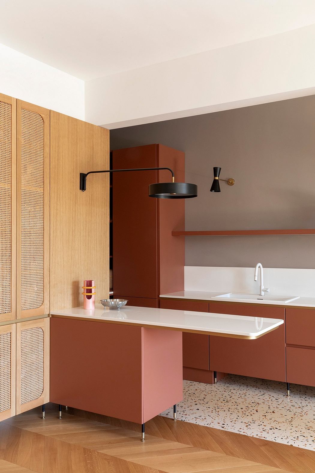 Modern kitchen with warm-toned cabinets, island, and terrazzo flooring pattern.